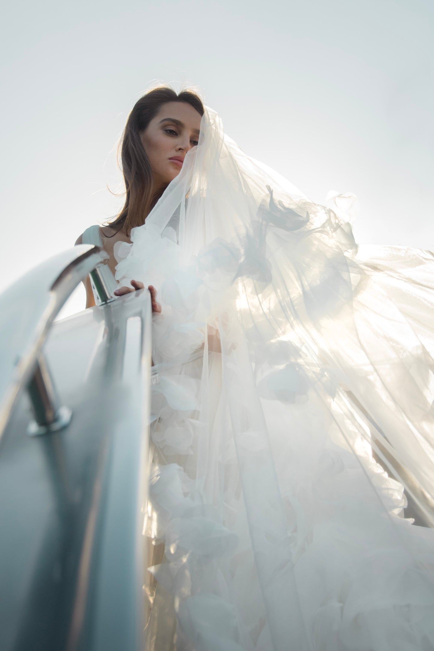 Ethereal tulle ball gown with deep V-neckline and layered airy skirt.