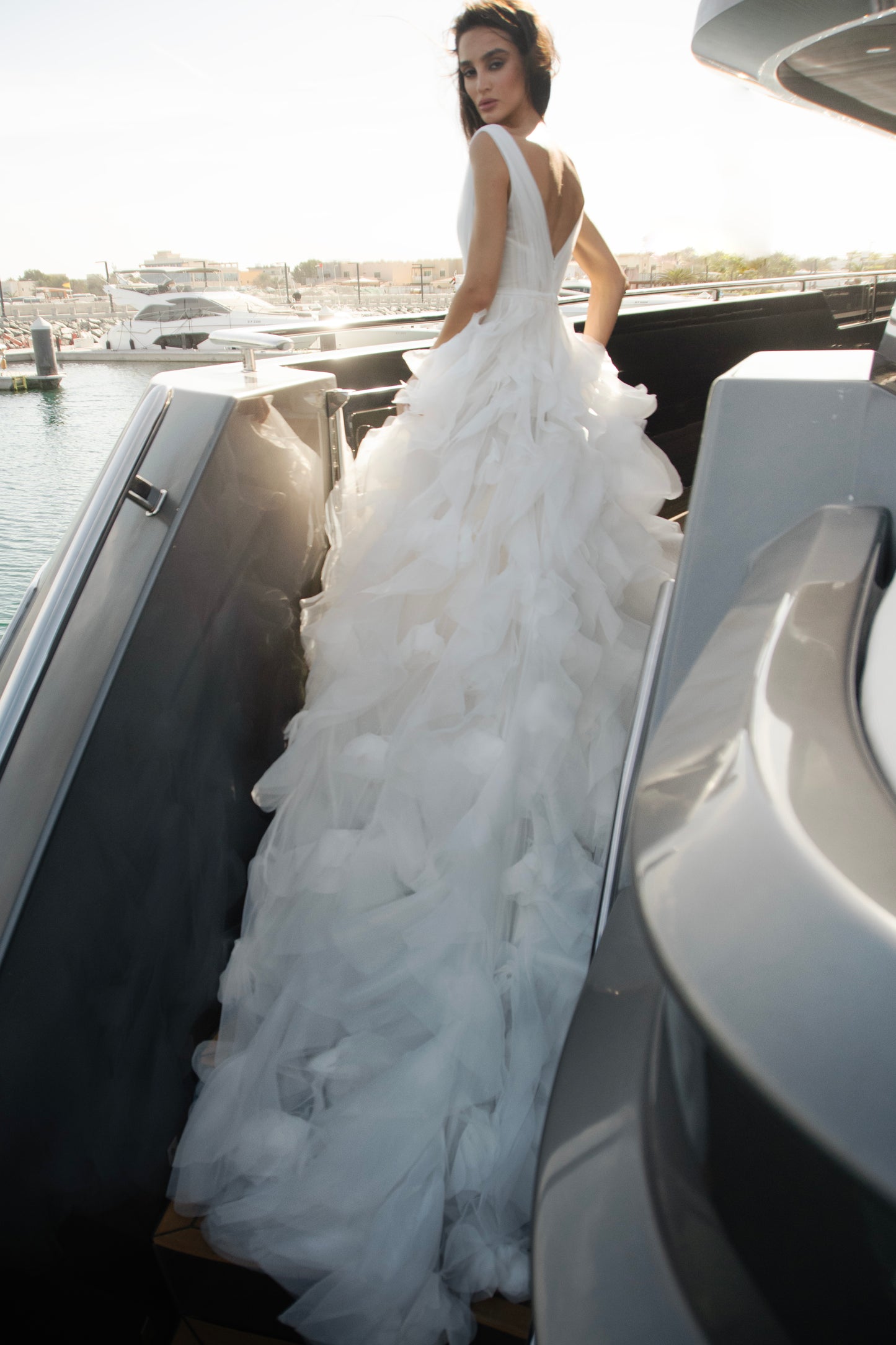 Ethereal tulle ball gown with deep V-neckline and layered airy skirt.
