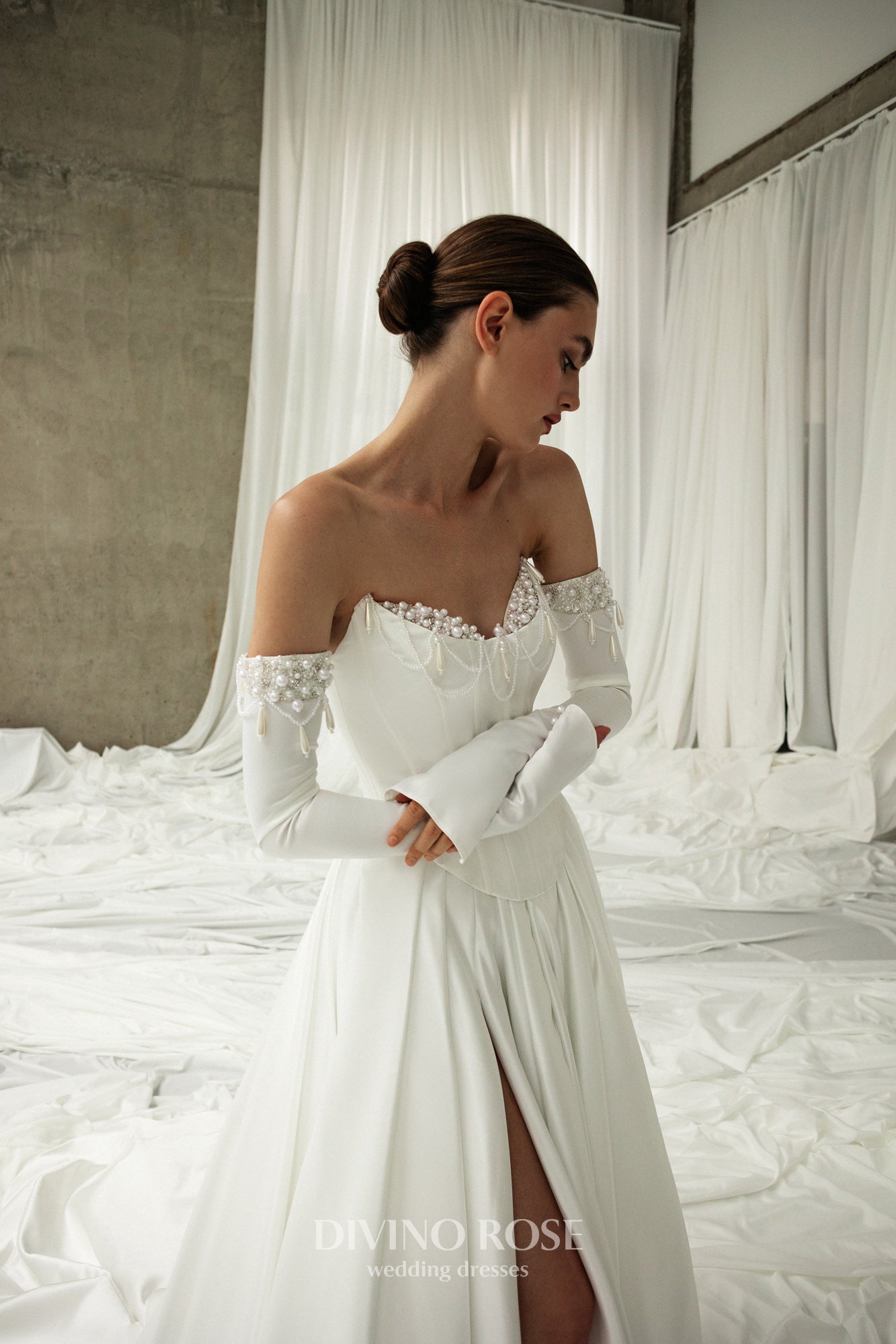 Atlas wedding dress with corset bodice, boat neckline, and slit skirt.