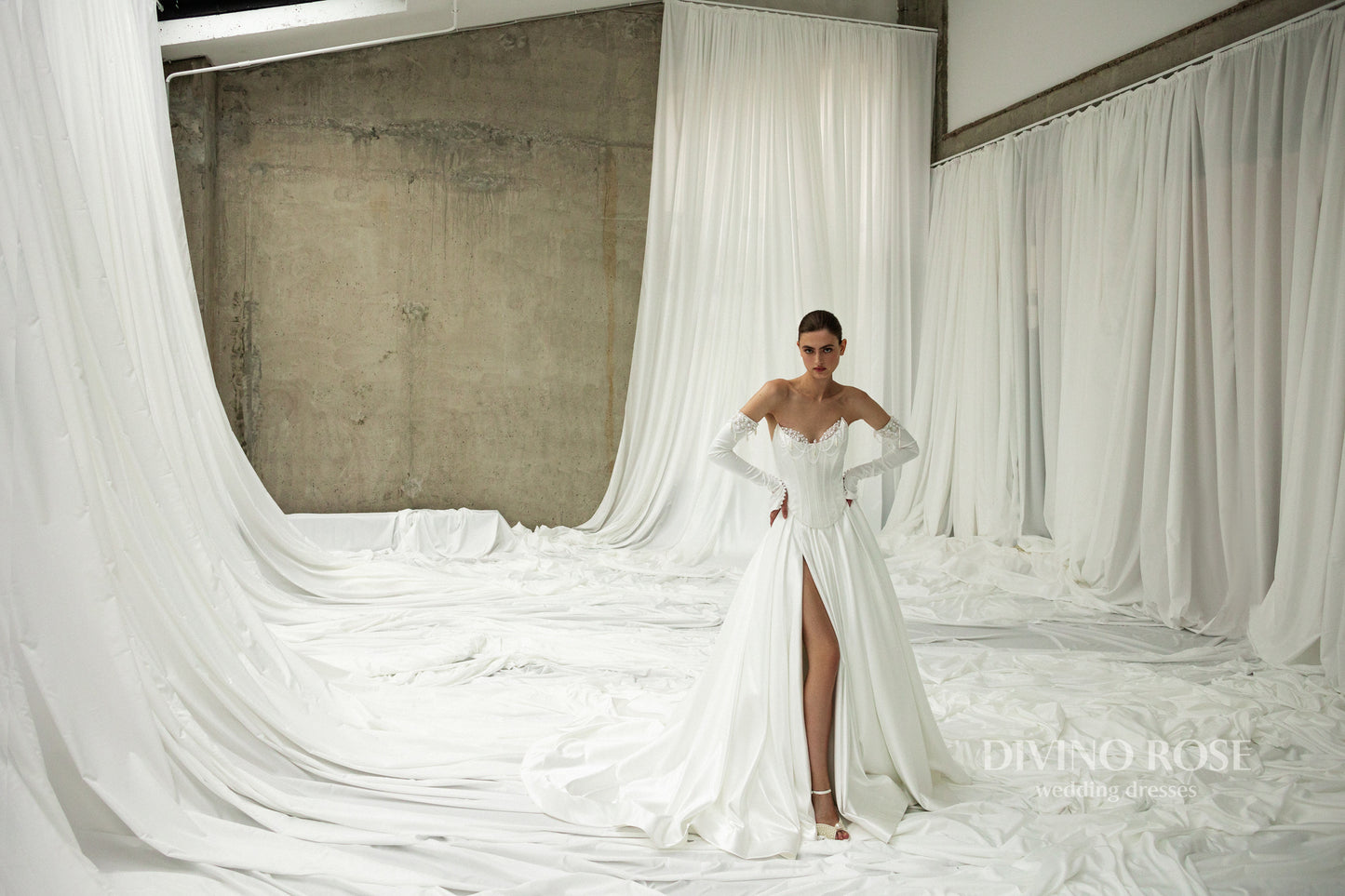 Pleated slit skirt wedding dress with corset bodice and luxurious atlas fabric.