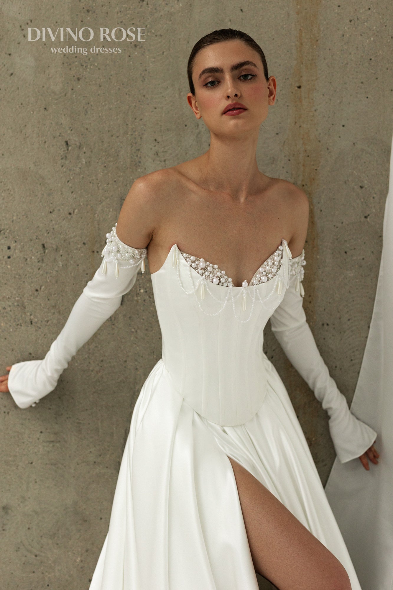 Atlas fabric bridal gown featuring a slit skirt and detachable long sleeves