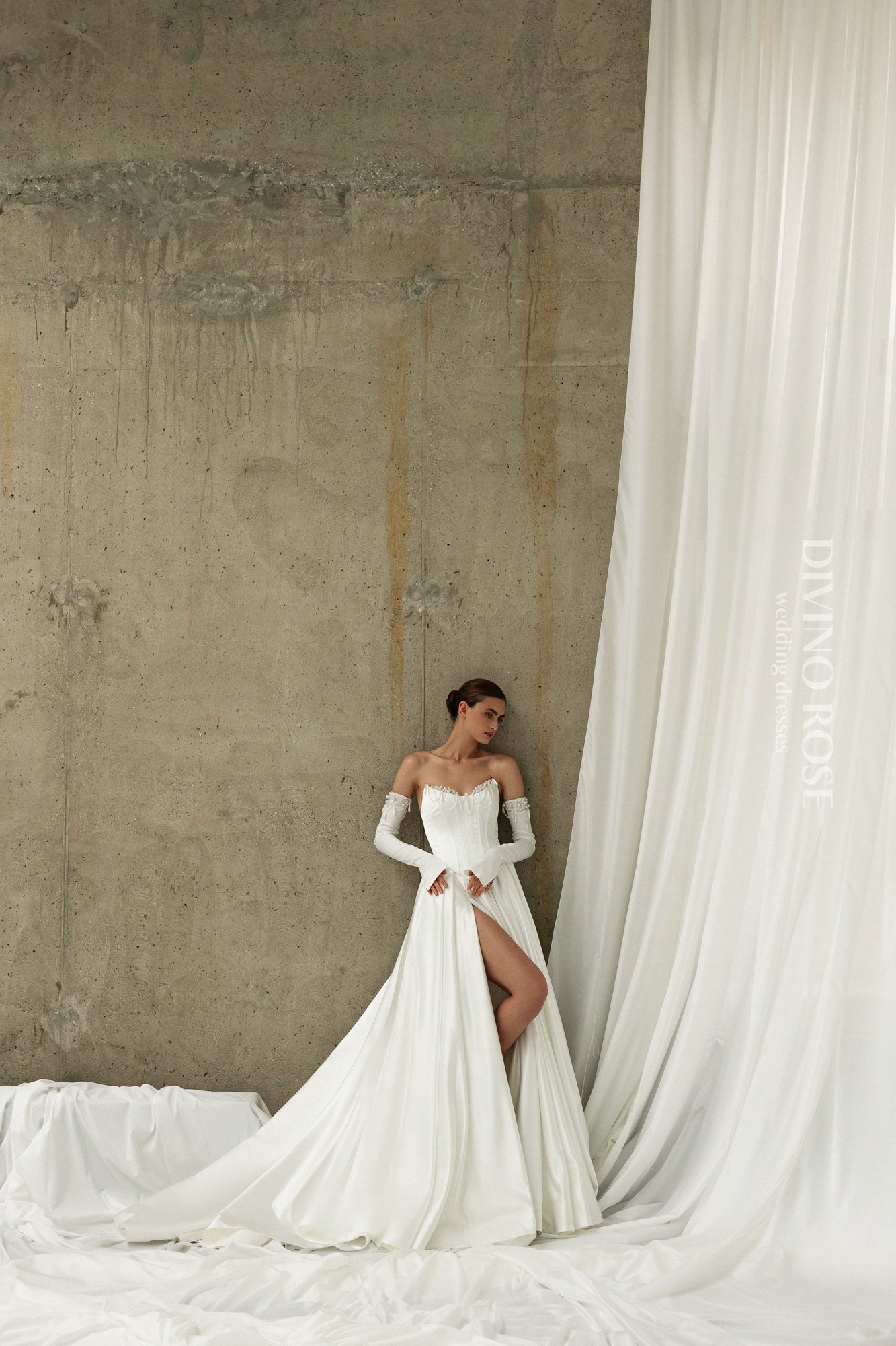 A-line atlas wedding gown with pleated slit skirt and removable sleeves