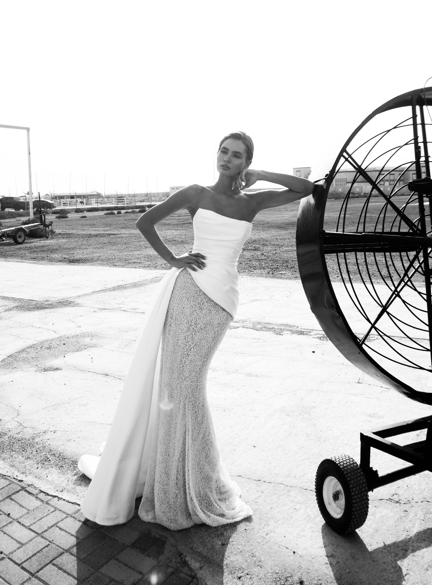 Strapless straight silhouette wedding dress with asymmetric Mikado bodice, lace skirt, zip closure, and flowing train for modern bridal style