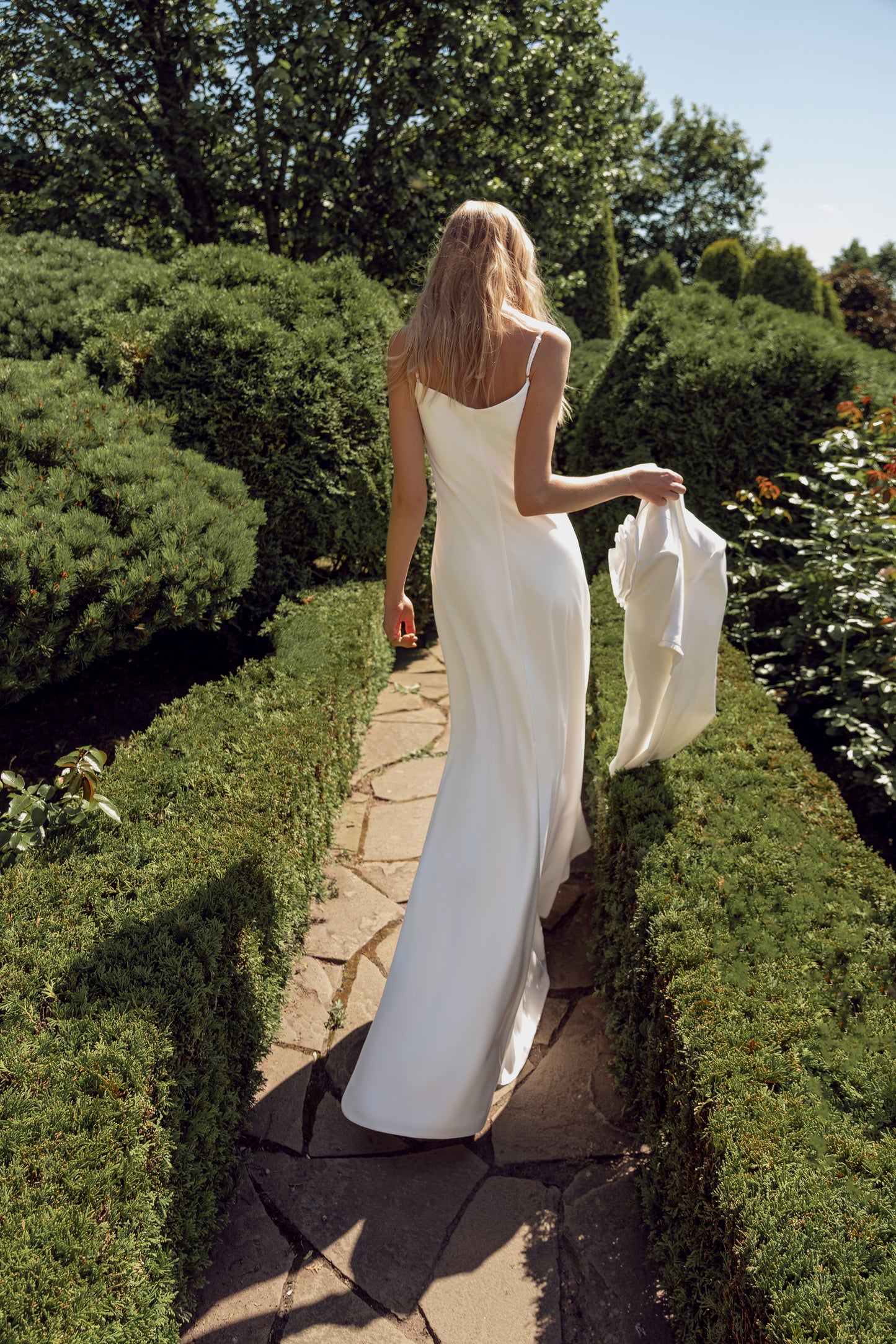 Minimalist sleeveless wedding dress with 3D floral jacket.