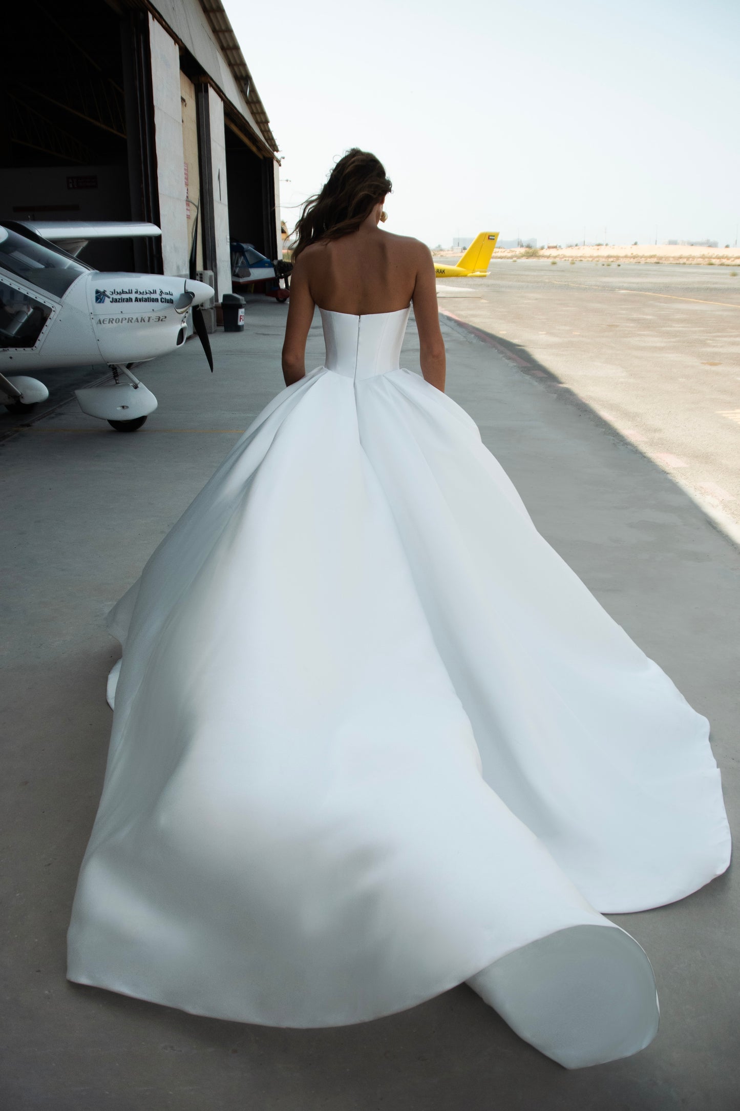 Strapless Mikado wedding dress with sculpted corset bodice, structured waist, and full flowing skirt in luminous white fabric for modern bridal look