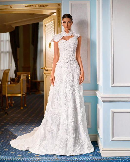Explore this sculpted lace A-line wedding dress with removable bolero, strapless bodice option, and chapel train. A couture bridal gown offering elegance and versatility.