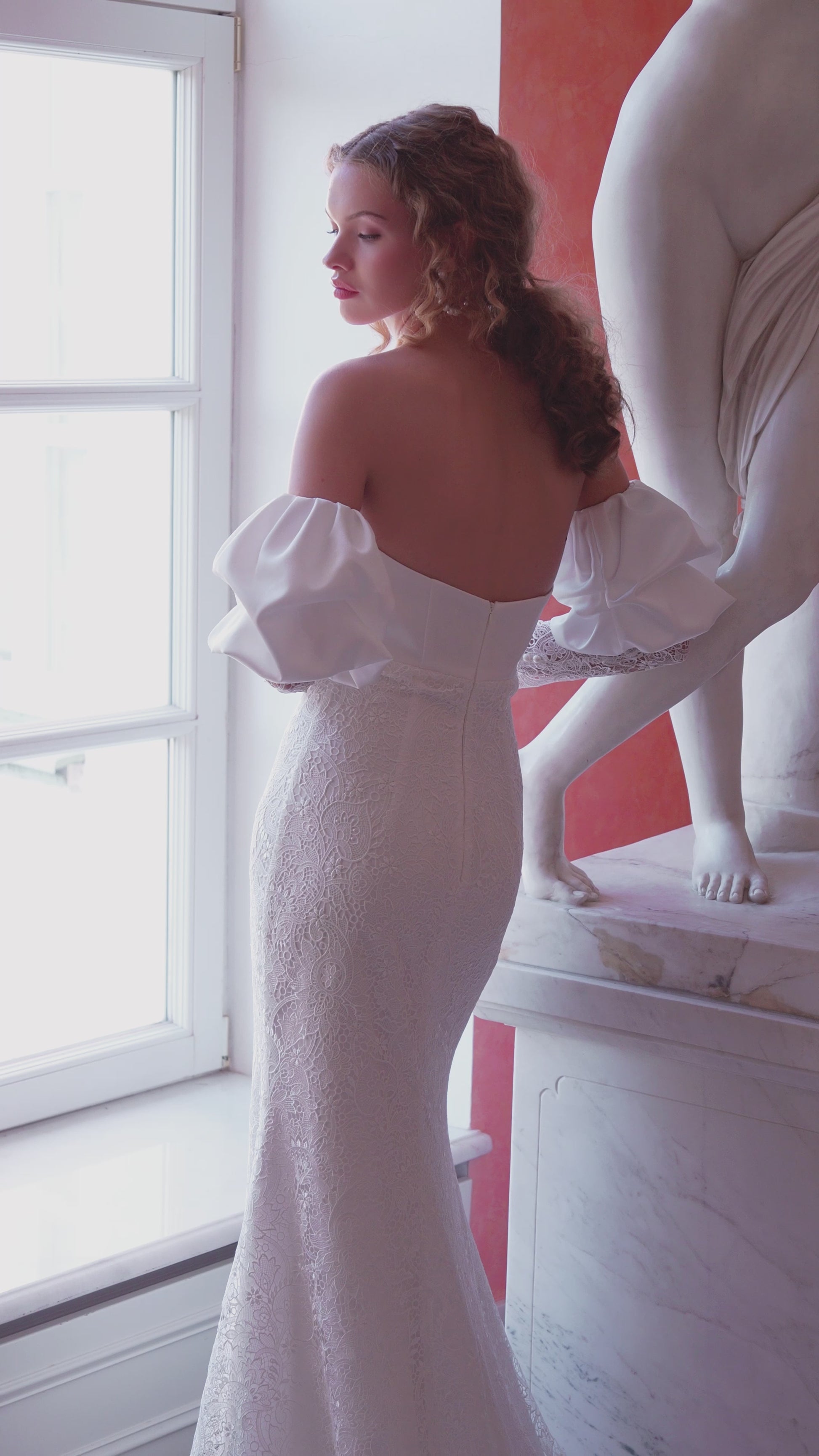 Off-shoulder lace wedding gown with puffed sleeves and fitted silhouette.