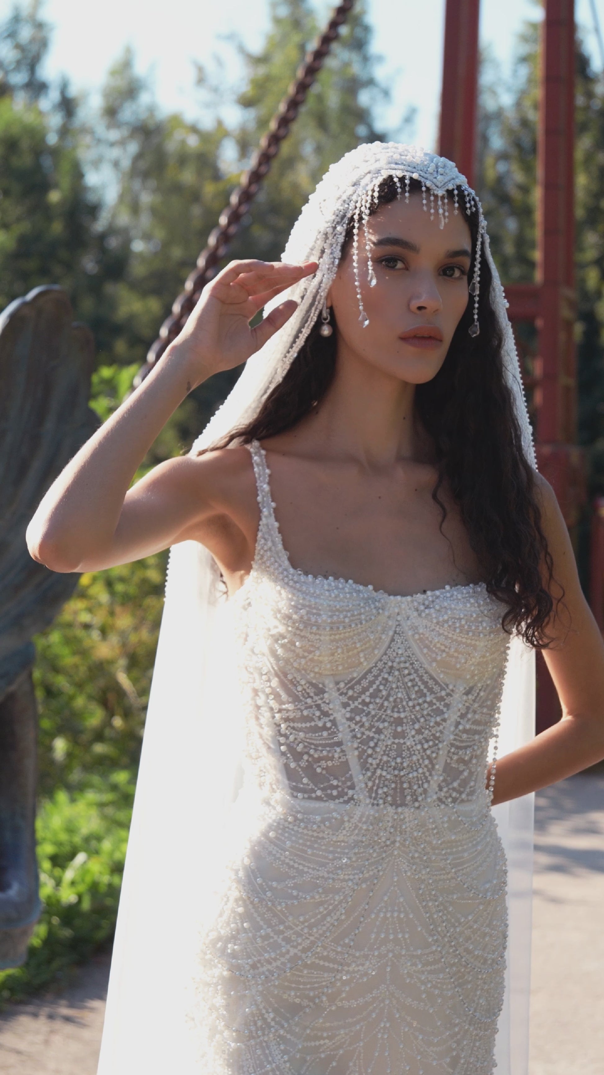 Beaded mermaid wedding gown with geometric pearl embroidery, sheer corset bodice, and elegant train.