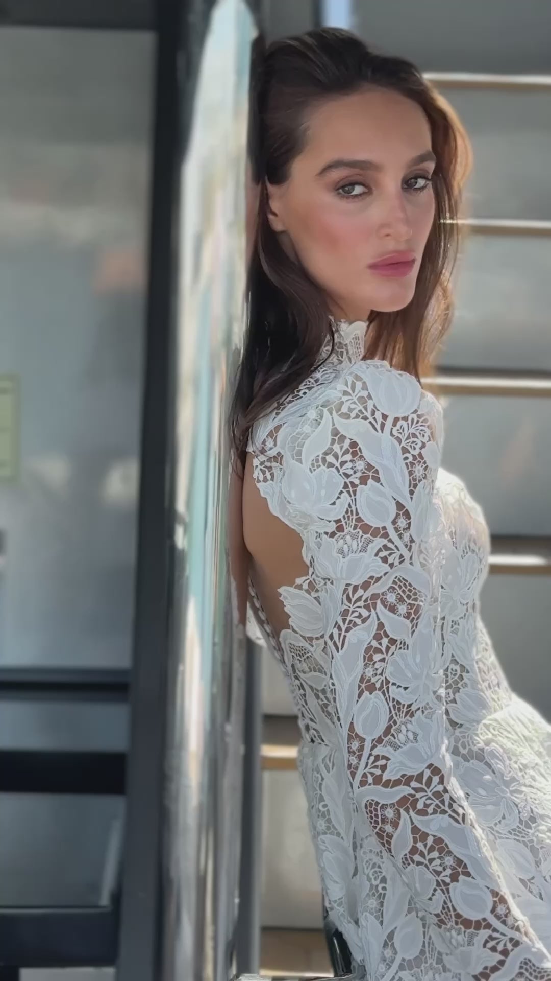 High-neck lace wedding gown with long puff sleeves, open back, and chapel-length train.