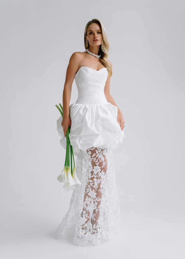Strapless satin wedding dress with a bubble-hem peplum over a sheer floral lace skirt