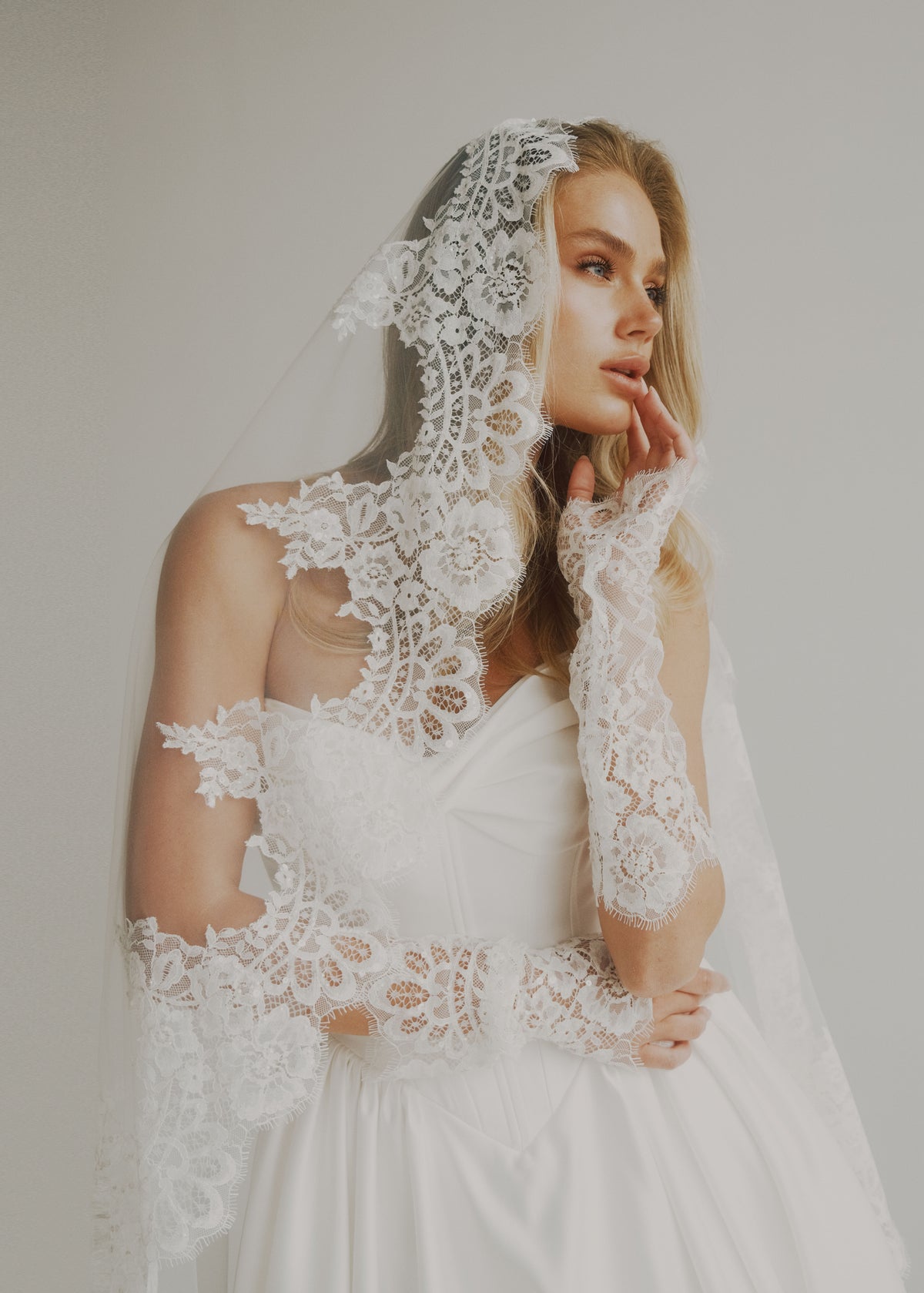 Soft-focus portrait of a satin bodice with a scalloped lace-trimmed veil