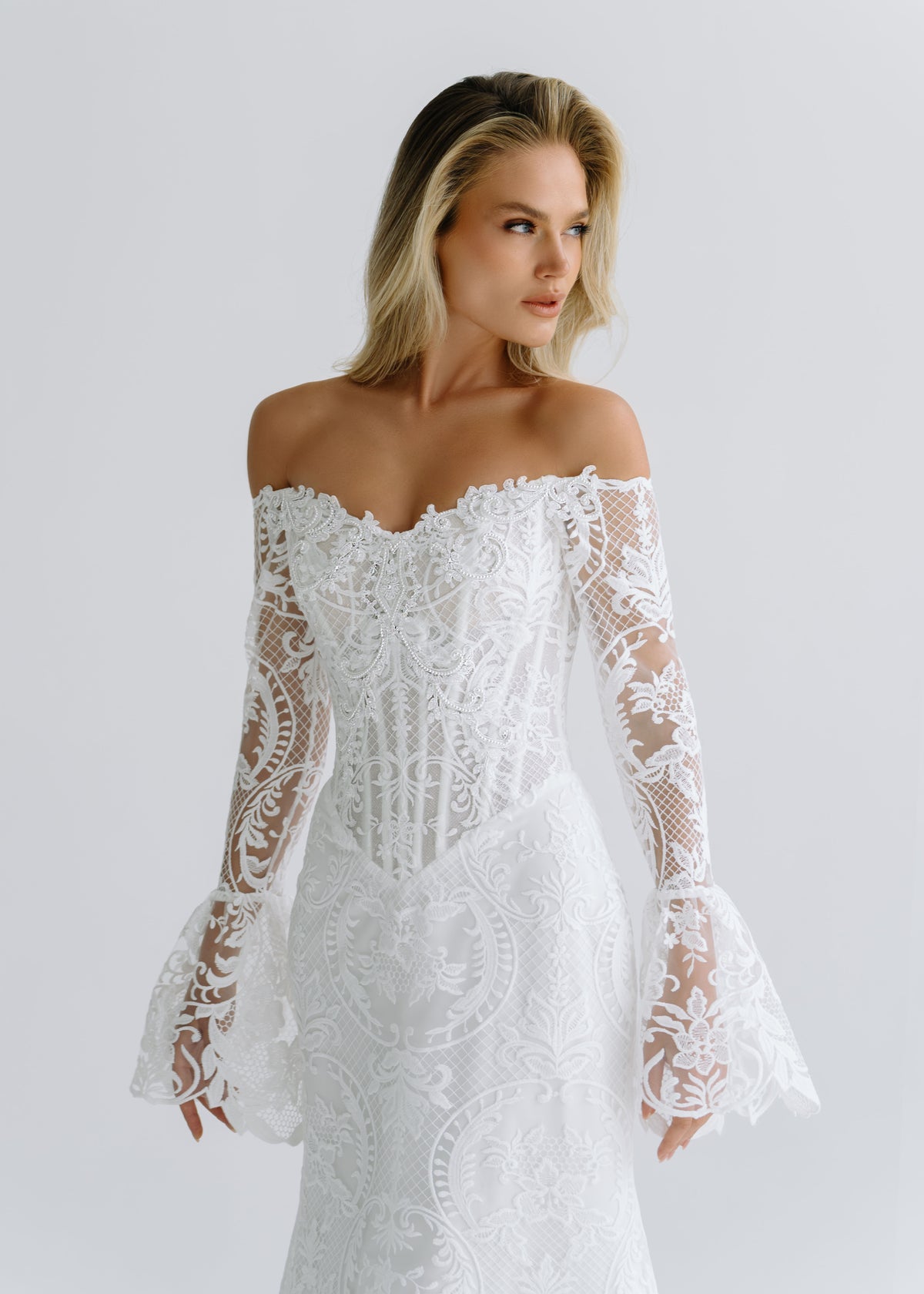 Close-up of an off-shoulder lace corset with bell-shaped lace cuffs