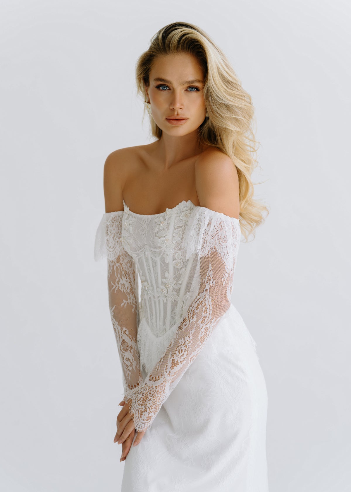 Close-up of an off-shoulder lace corset with long lace sleeves