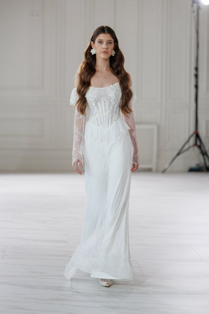 Model walking in a lace fit-and-flare wedding dress in a bright studio