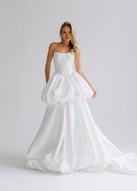 Strapless satin corset dress with a bubble-hem peplum over a long layered skirt with a train