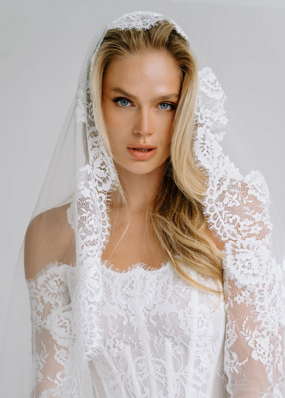 Close-up of a lace-trimmed veil over an off-shoulder lace corset bodice