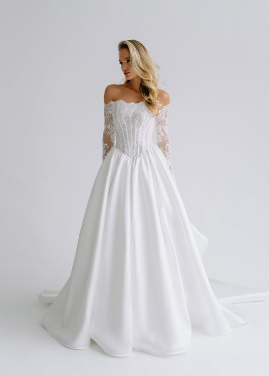 Satin wedding dress with an off-shoulder lace corset, long lace sleeves and a full skirt, front view