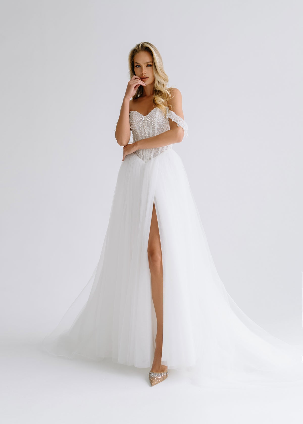 Tulle A-line wedding dress with an off-shoulder beaded corset and a high slit, front view