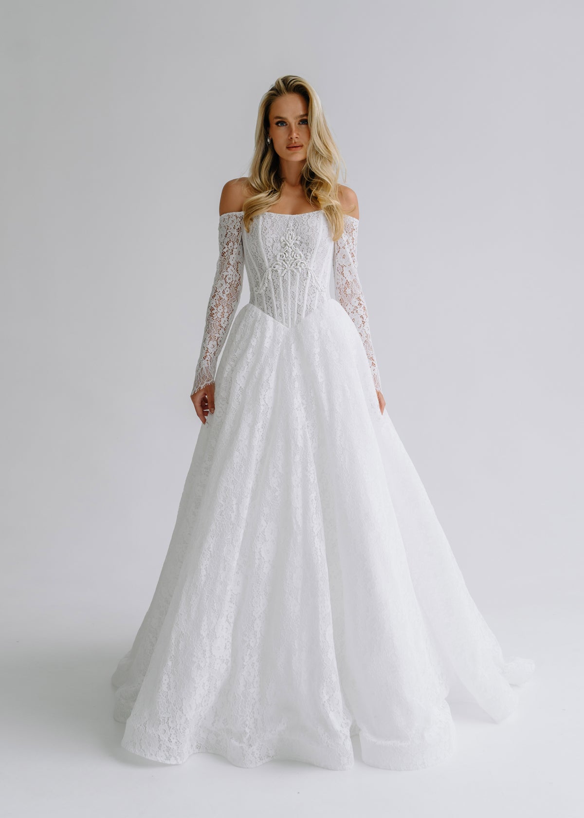 Lace A-line wedding dress with an off-shoulder neckline and long lace sleeves, front view