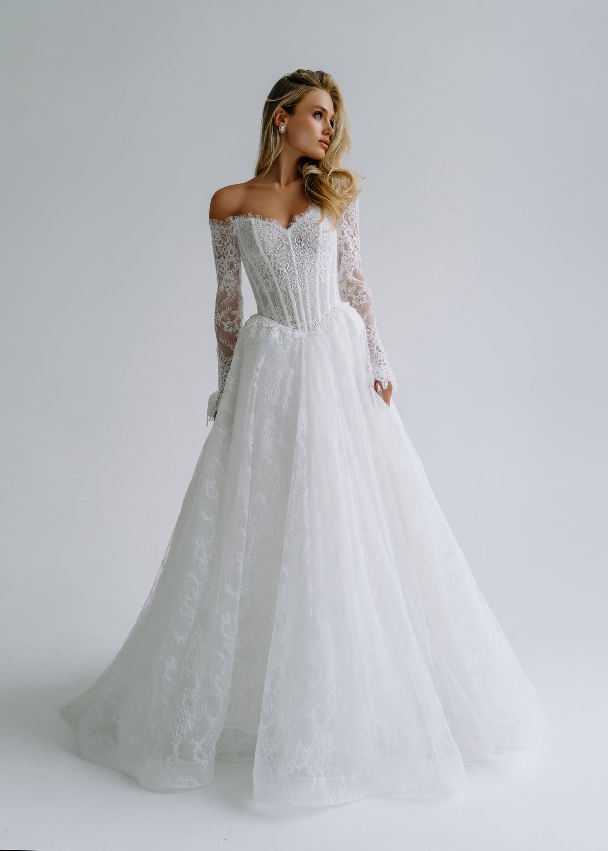 Lace A-line wedding dress with an off-shoulder corset and long lace sleeves, front view
