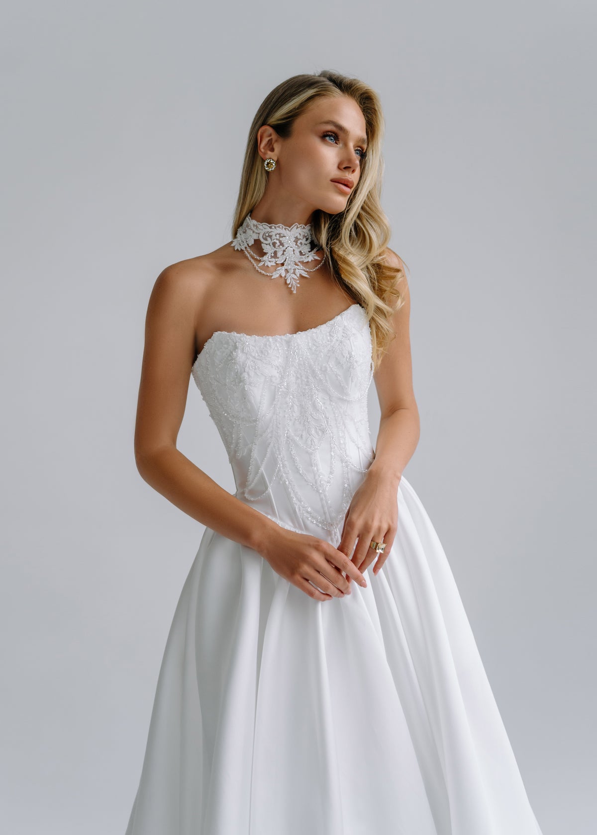 Close-up of a strapless corset bodice with a beaded lace choker collar
