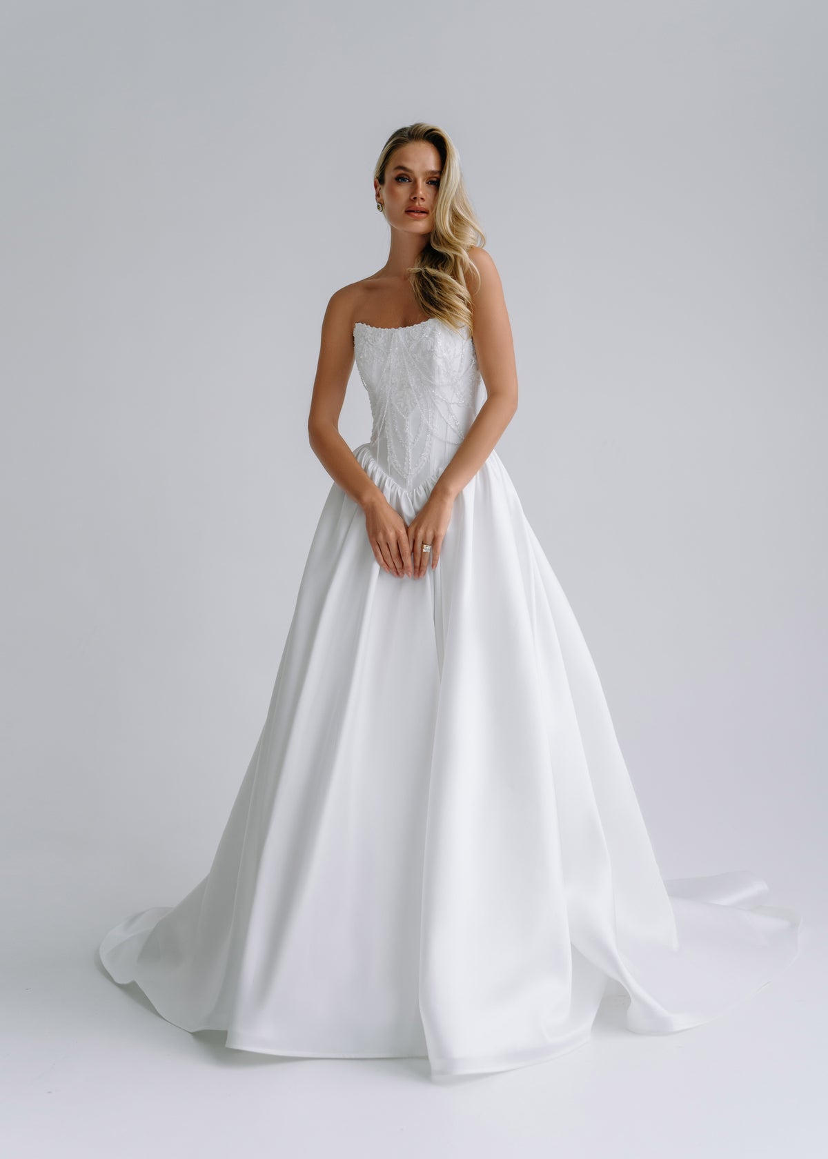 Strapless satin A-line wedding dress with an embroidered corset bodice, front view