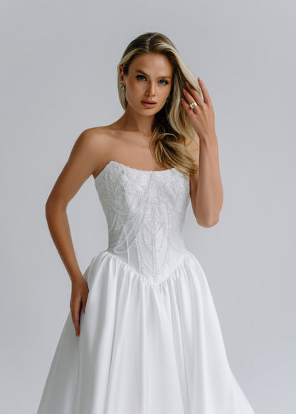 Close-up of a strapless beaded corset bodice on a satin wedding dress