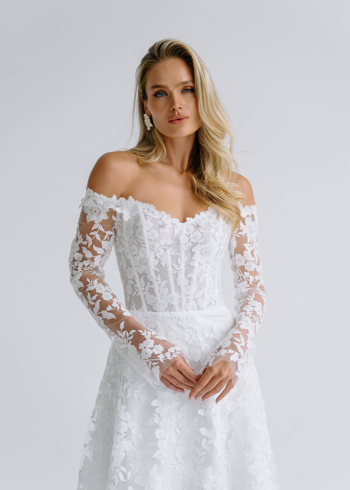 Close-up of an off-shoulder sweetheart lace corset with long floral lace sleeves