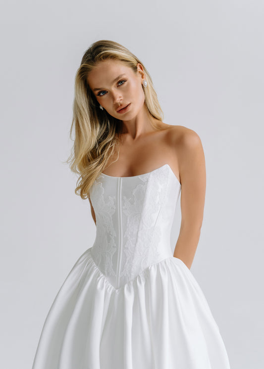 Close-up of a strapless straight-neckline satin corset bodice with a full skirt