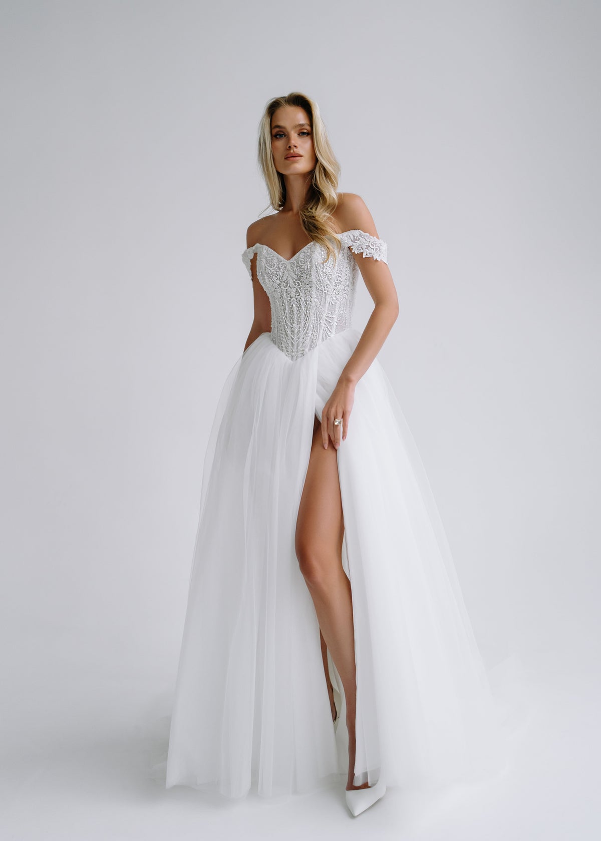 Tulle A-line wedding dress with a beaded lace corset, lace cap straps and a high slit, front view