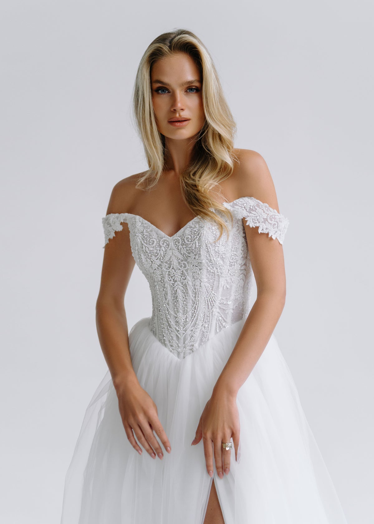 Close-up of a beaded lace corset with an off-shoulder sweetheart neckline and a slit tulle skirt