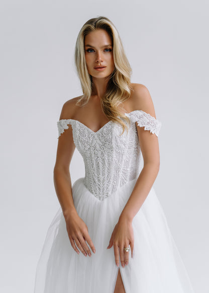 Close-up of a beaded lace corset with an off-shoulder sweetheart neckline and a slit tulle skirt