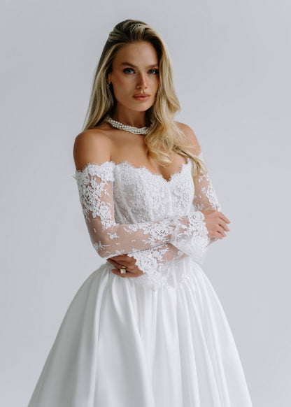 Close-up of an off-shoulder lace corset bodice with long lace sleeves, styled with a choker necklace
