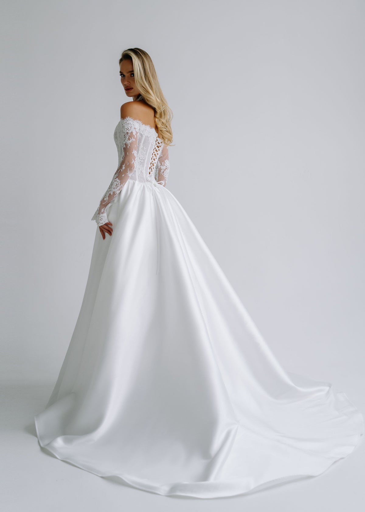 Side view of a satin A-line wedding dress with a sweeping train