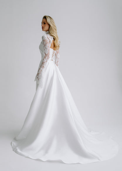 Back view of a satin wedding dress with a lace bolero, a lace-up back and a flowing train