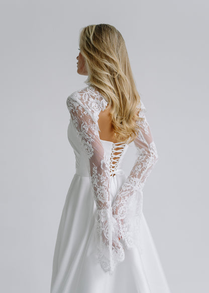 Back view of a long-sleeve lace bolero over a lace-up corset back
