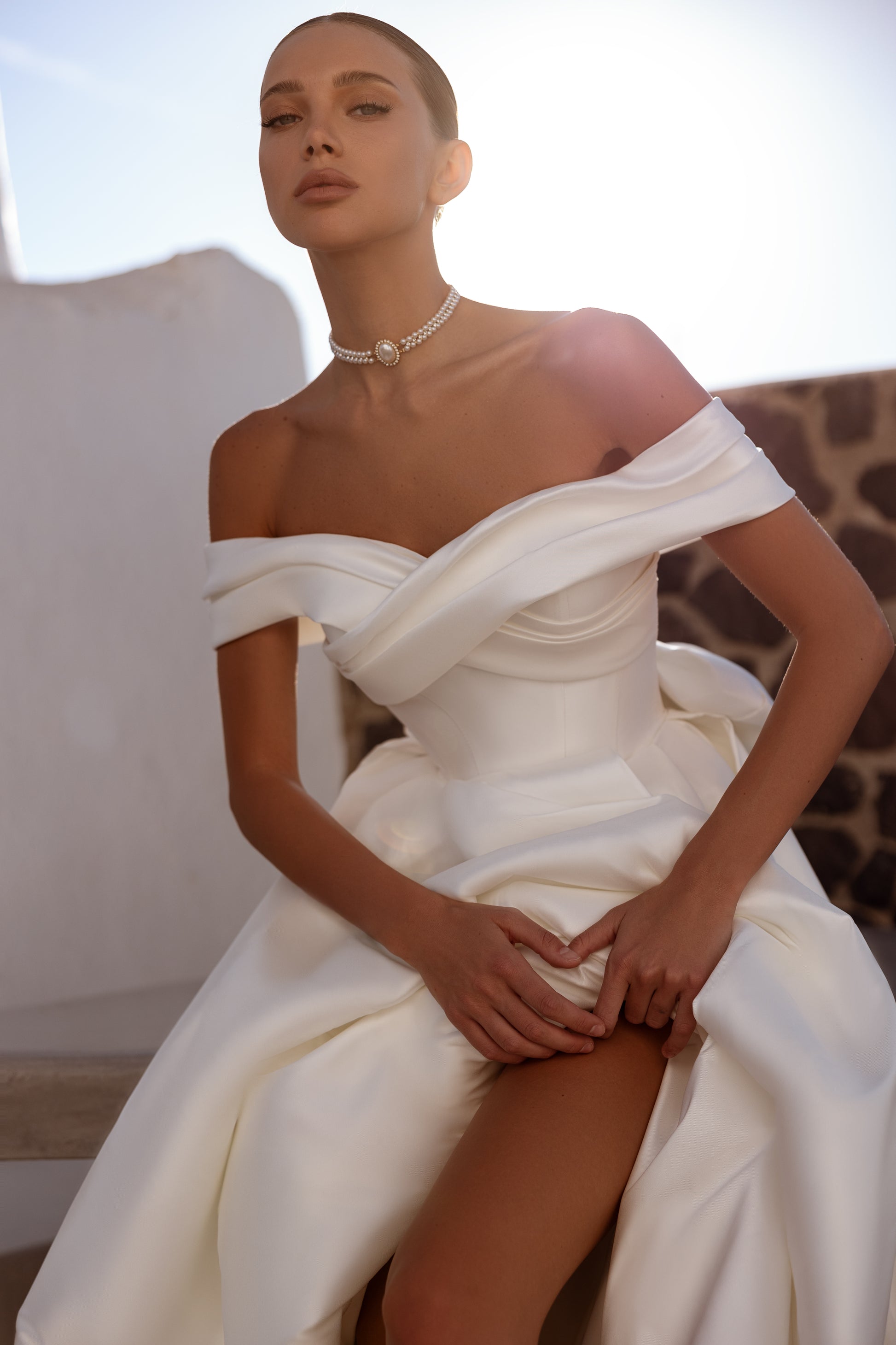 A-line wedding dress with off-the-shoulder neckline and bow.