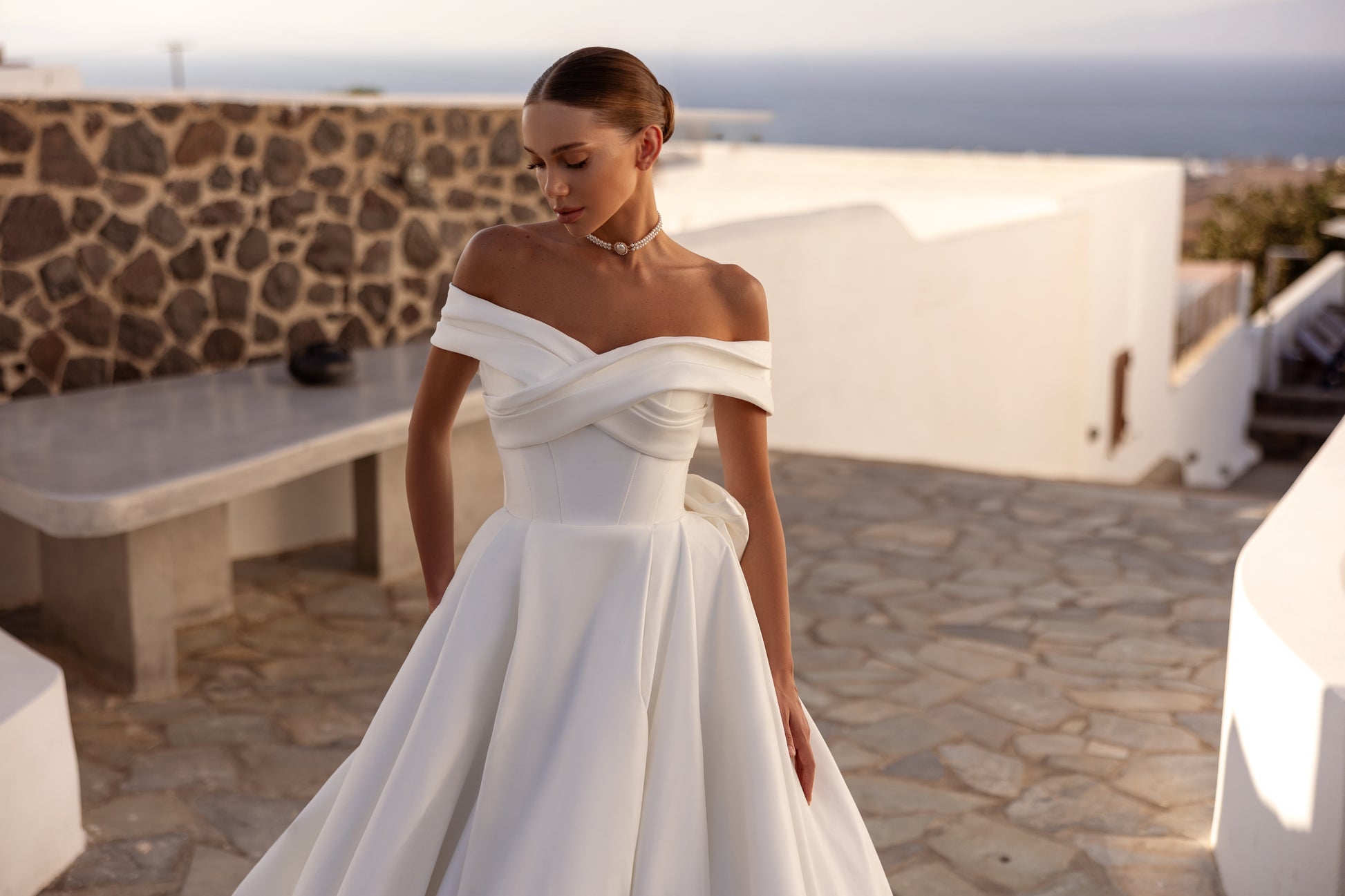 A-line wedding dress with off-the-shoulder neckline and bow.
