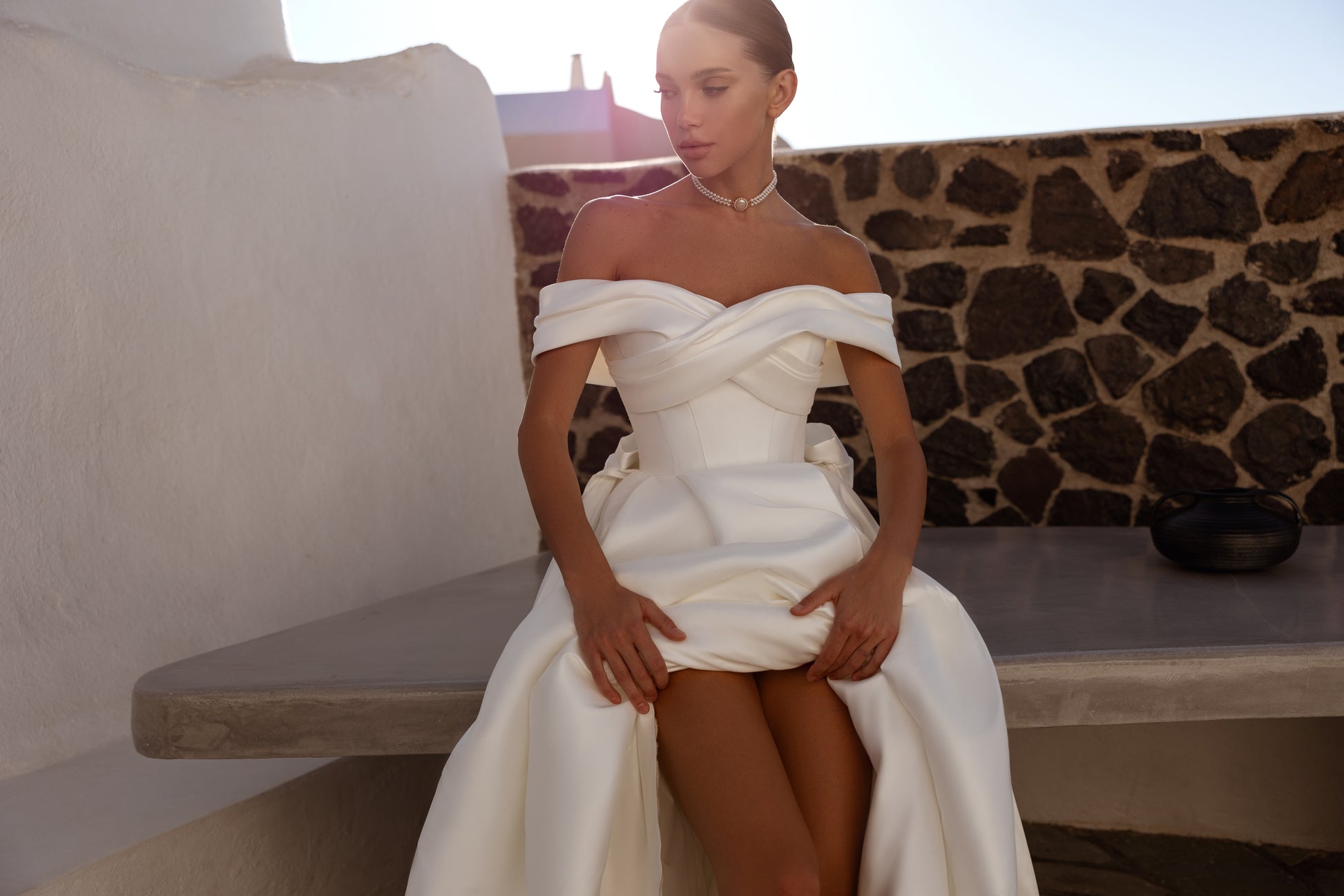 A-line wedding dress with off-the-shoulder neckline and bow.