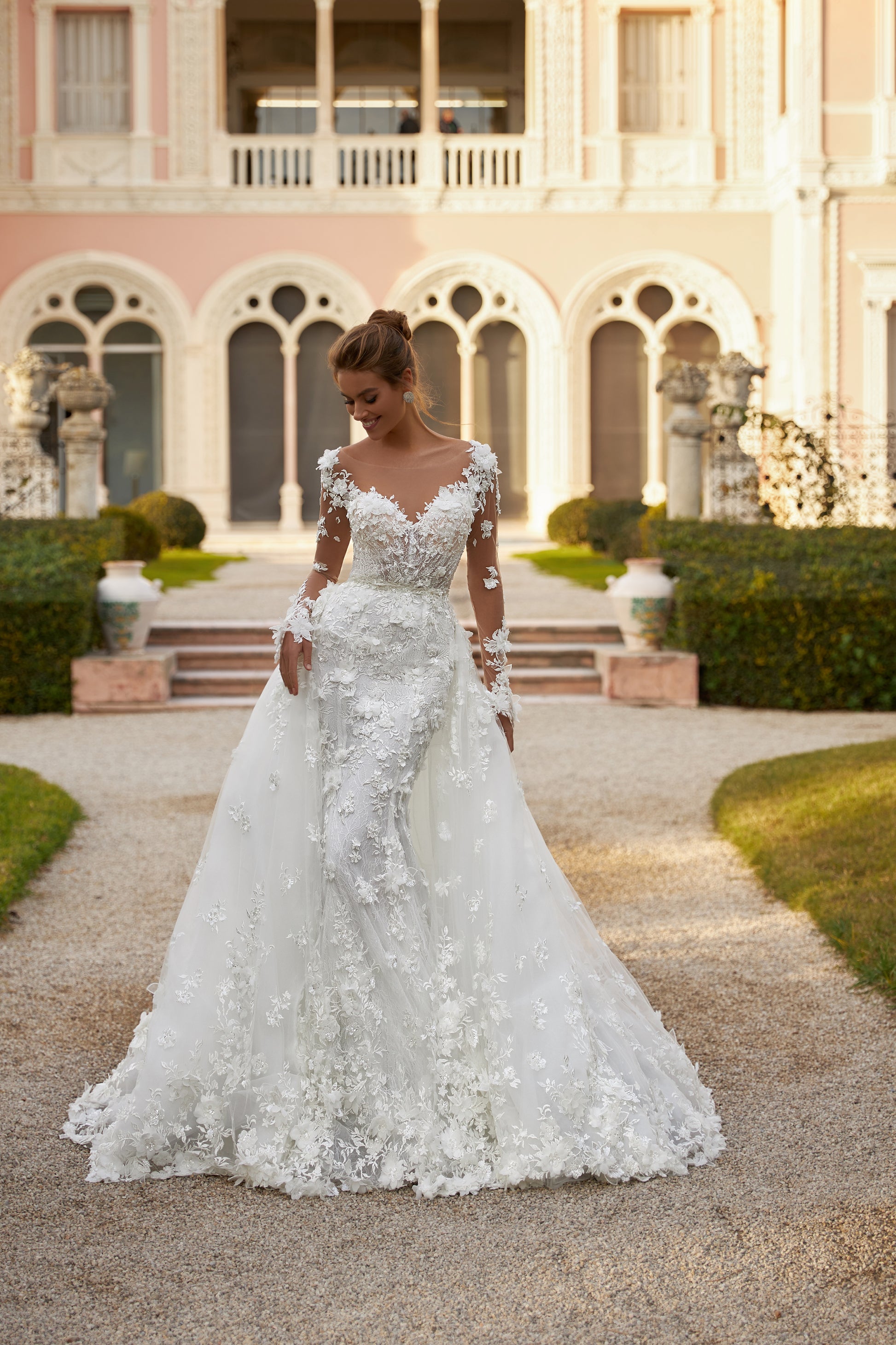 Fitted Mermaid wedding gown with illusion long sleeves, V-neckline, open V-shaped back, lace appliques, 3D flowers, bead and sequin embroidery, detachable chapel train overskirt, Chantilly lace.