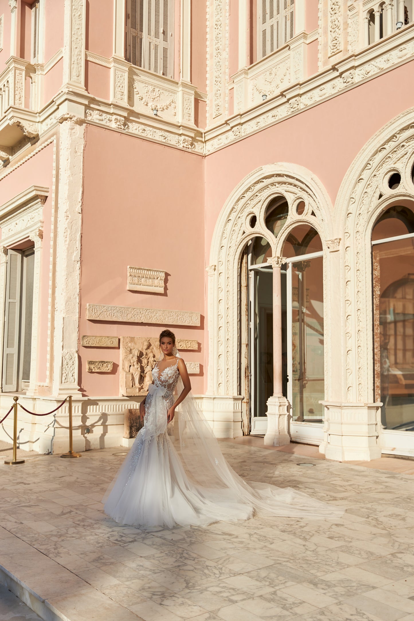 Modern mermaid wedding dress with knee-high cut, detachable waist bow, lace appliques, bead and pearl embroidery, 50 cm train, and matching veil. Made of lace and tulle for a timeless bridal look.