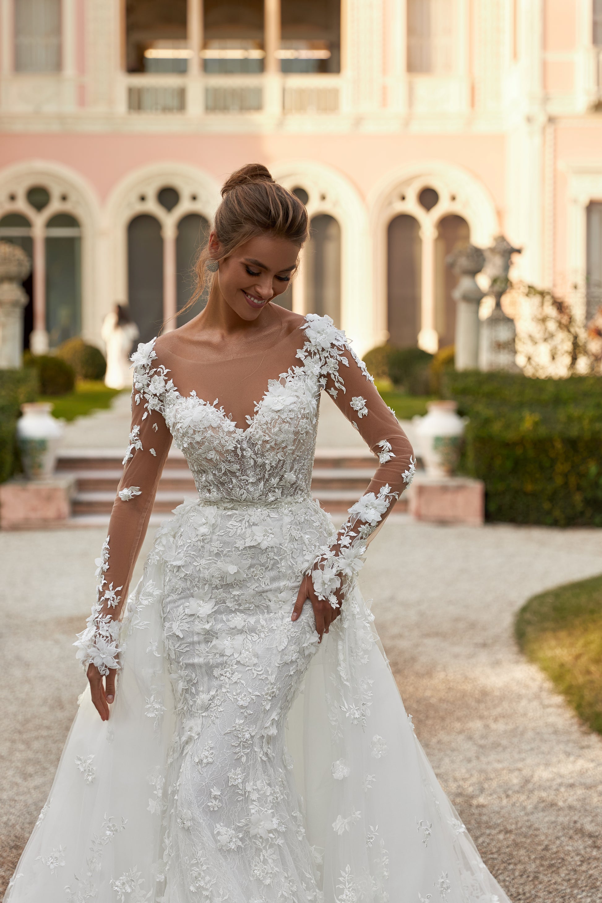 Fitted Mermaid wedding gown with illusion long sleeves, V-neckline, open V-shaped back, lace appliques, 3D flowers, bead and sequin embroidery, detachable chapel train overskirt, Chantilly lace.