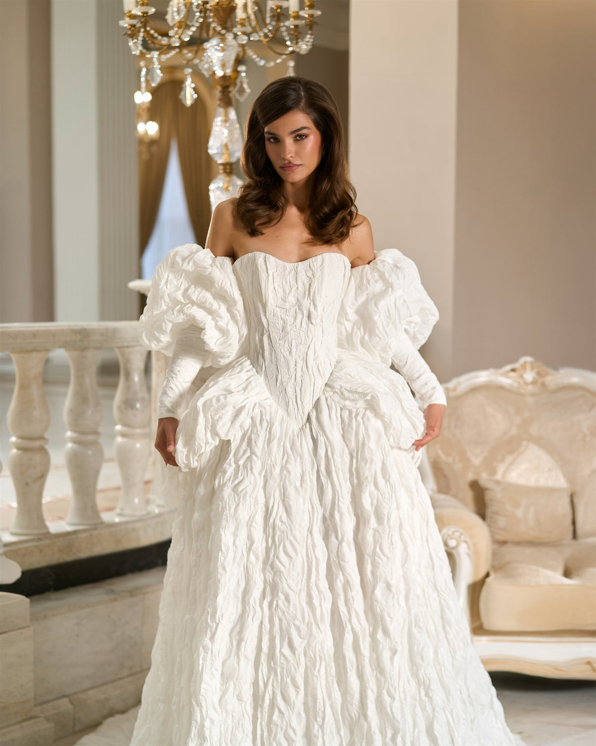 White textured taffeta wedding dress shown from the front, with a pointed basque waist, puff sleeves and sculptural hip draping.
