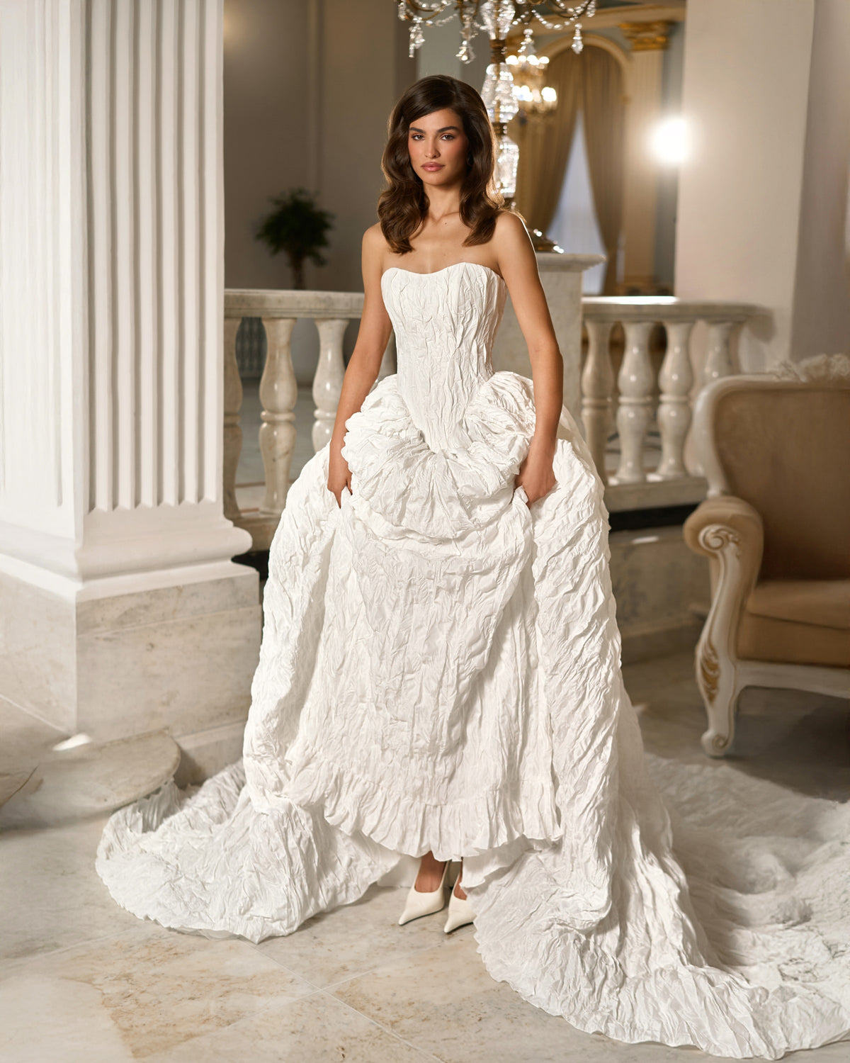 Front view of the white textured taffeta wedding dress without puff sleeves, showing its open skirt and long train.