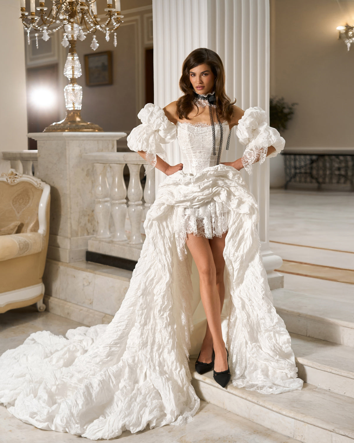 Full-length front view of a taffeta and lace high-low wedding dress with detachable puff sleeves, a corset bodice and long train.