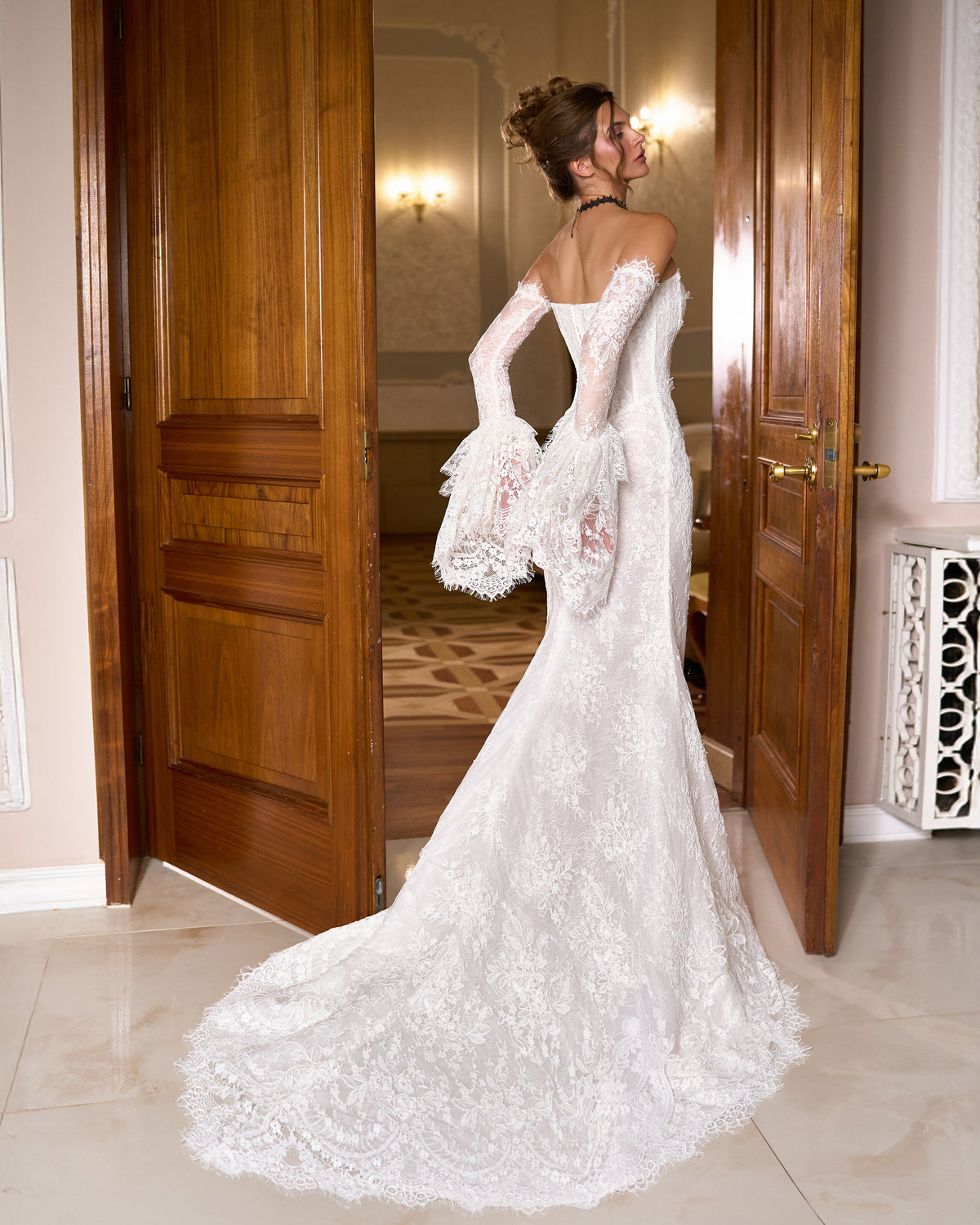 Back view of mermaid lace wedding dress with long lace bell sleeves and scalloped train