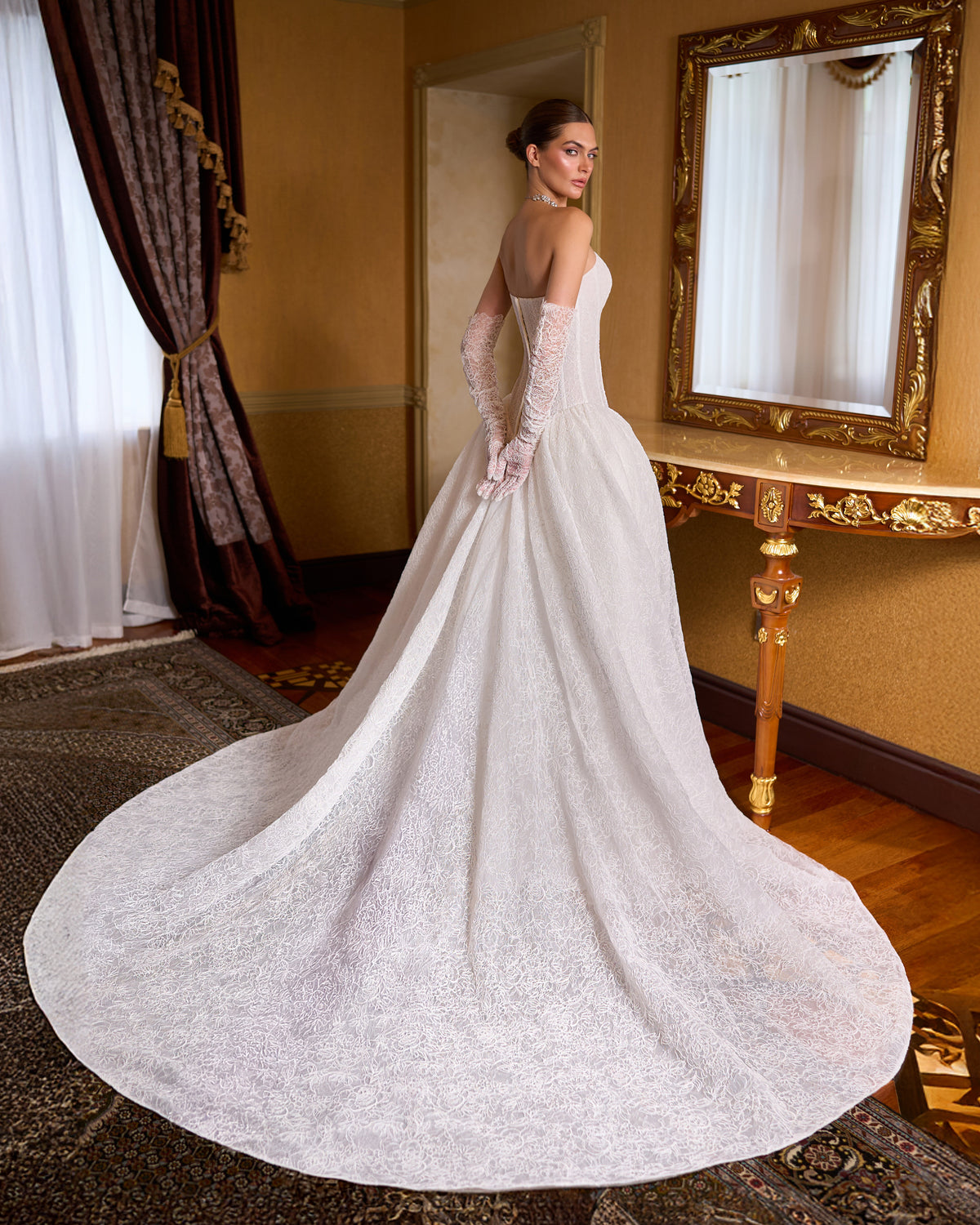Back view of lace ball gown wedding dress with strapless corset bodice and long sweeping train