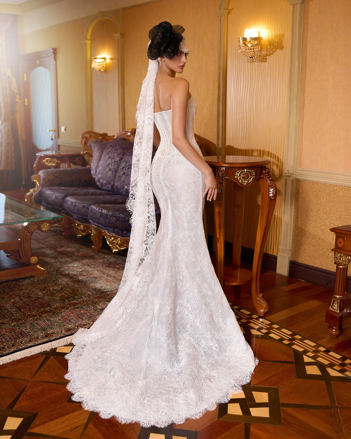 Mermaid wedding dress with floral lace, a low back, scalloped sweep train and a trailing lace bandana.