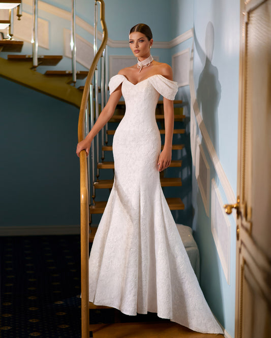 Full-length lace mermaid wedding dress with fit and flare silhouette, draped off-shoulder sleeves, V-neckline, removable lace and pearl choker, lace-up back closure, and elegant fishtail train for modern bridal look