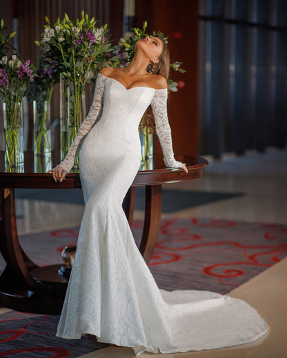 Off the shoulder lace mermaid wedding dress with long sleeves.